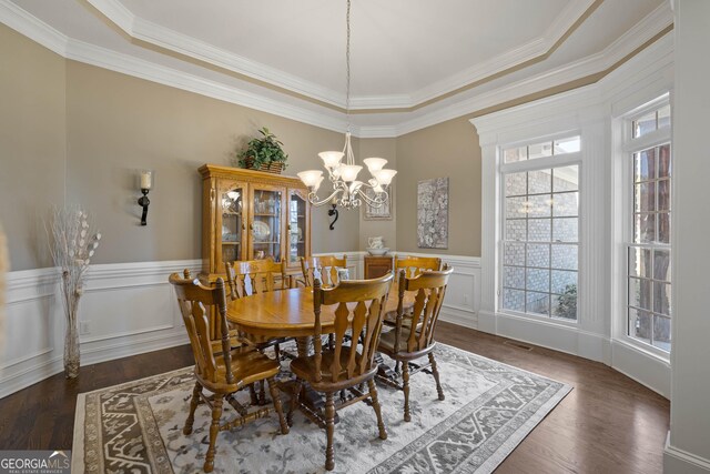 dining area featuring dark wood-type flooring, wainscoting, visible vents, and a notable chandelier