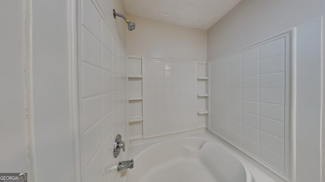 bathroom with shower / washtub combination and a textured ceiling