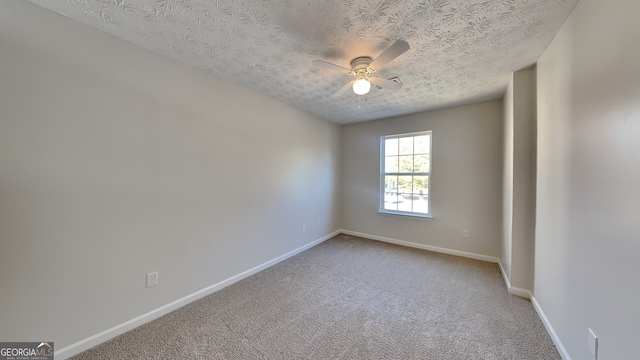 carpeted spare room with ceiling fan and a textured ceiling