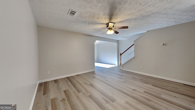 unfurnished room with ceiling fan, light hardwood / wood-style floors, and a textured ceiling