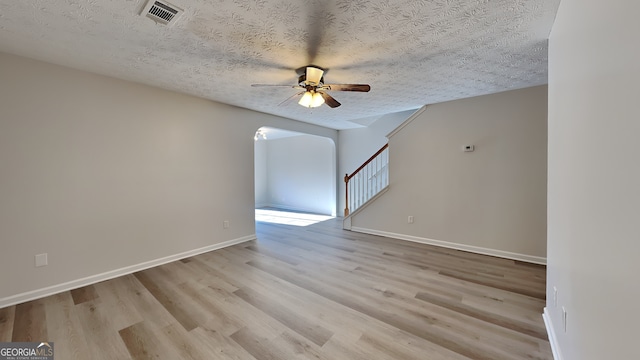 unfurnished room featuring a textured ceiling, light hardwood / wood-style floors, and ceiling fan