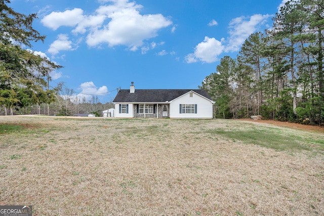 view of front of property with a chimney and a front lawn