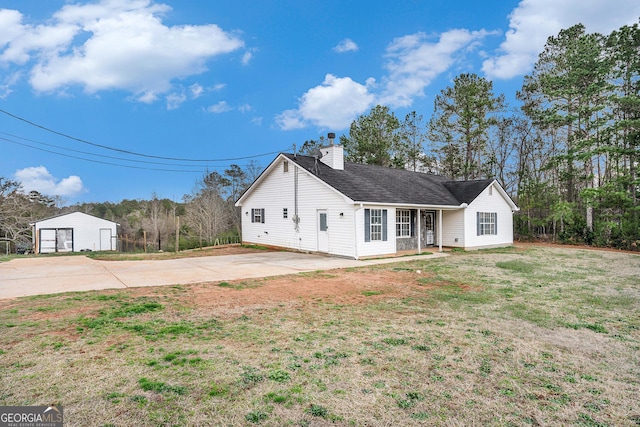 view of front of home featuring a garage, roof with shingles, a chimney, and a front yard