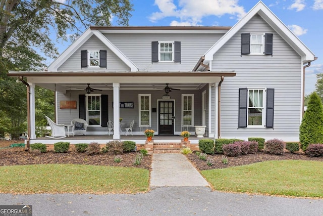 view of front facade with ceiling fan, covered porch, and a front lawn