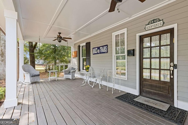 wooden deck featuring covered porch and ceiling fan