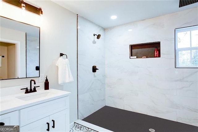 bathroom featuring vanity and tiled shower