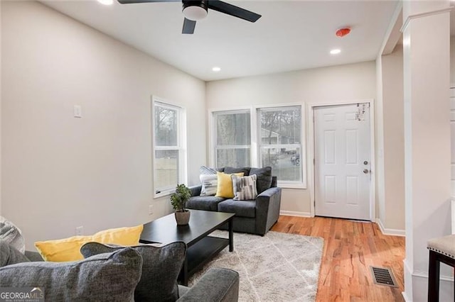 living room featuring light hardwood / wood-style flooring and ceiling fan