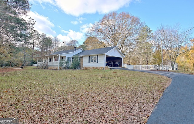 ranch-style house featuring a carport, covered porch, and a front lawn