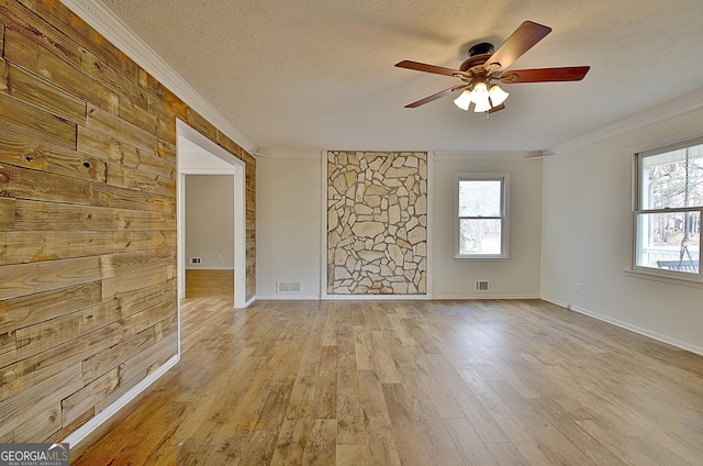 spare room featuring crown molding, ceiling fan, light hardwood / wood-style flooring, and a textured ceiling