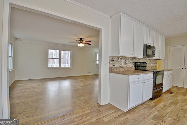 kitchen featuring crown molding, black appliances, light hardwood / wood-style flooring, backsplash, and white cabinets