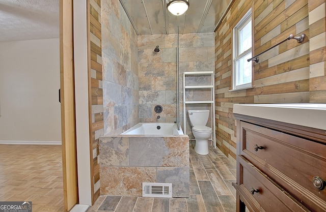 bathroom with hardwood / wood-style floors, tiled bath, wooden walls, and toilet