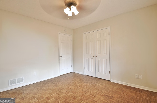 unfurnished bedroom with ceiling fan, a closet, and light parquet floors