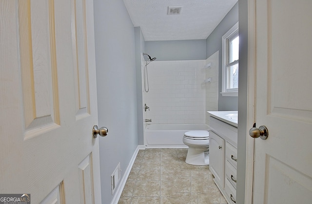 full bathroom with tiled shower / bath combo, vanity, a textured ceiling, and toilet