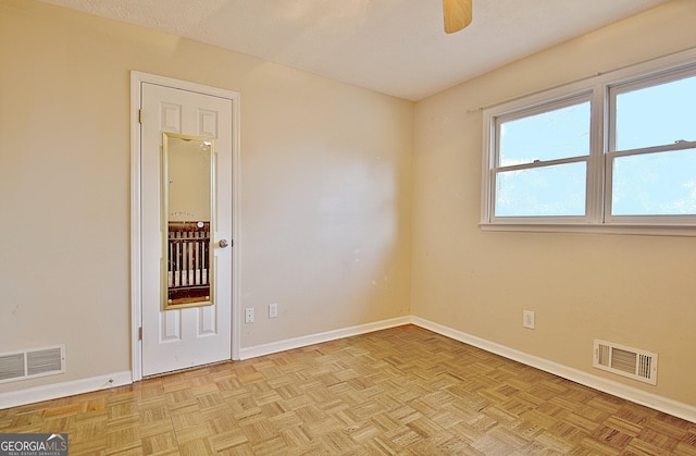 unfurnished room featuring ceiling fan, a textured ceiling, and light parquet floors