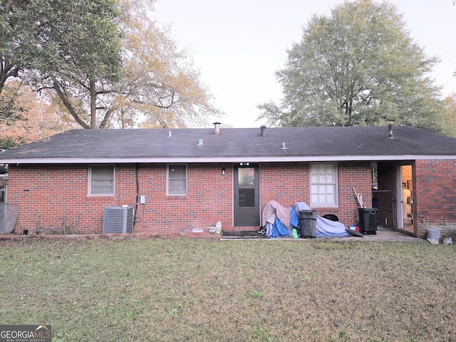 back of house featuring a yard and central AC unit