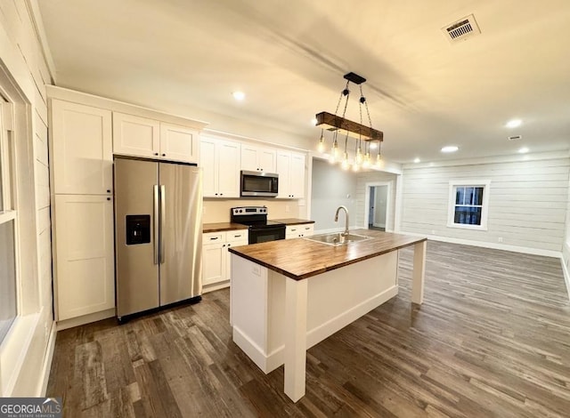 kitchen featuring sink, stainless steel appliances, dark hardwood / wood-style floors, a center island with sink, and white cabinets