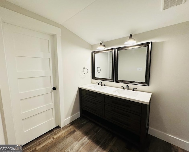 bathroom with hardwood / wood-style floors, vanity, and vaulted ceiling