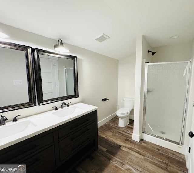 bathroom with vanity, toilet, wood-type flooring, and walk in shower