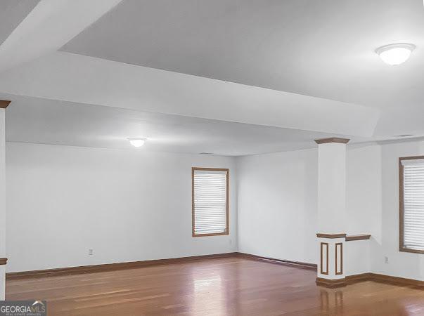 unfurnished room featuring plenty of natural light and wood-type flooring