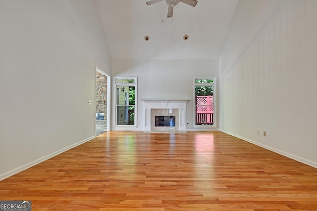 unfurnished living room featuring ceiling fan, plenty of natural light, high vaulted ceiling, and light hardwood / wood-style flooring