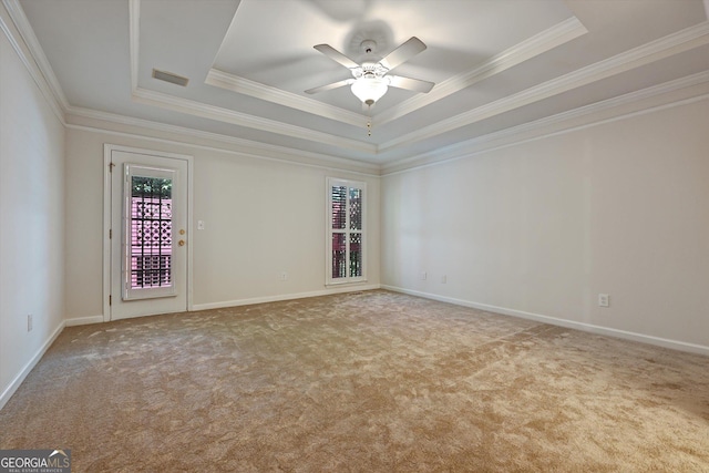 empty room with ceiling fan, a raised ceiling, and ornamental molding