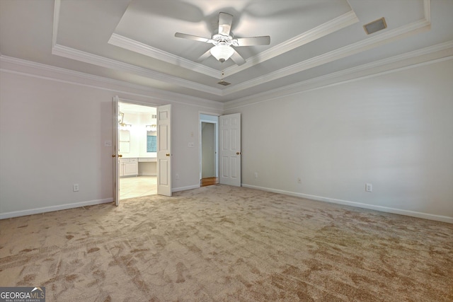 unfurnished bedroom with light carpet, a tray ceiling, ceiling fan, and crown molding