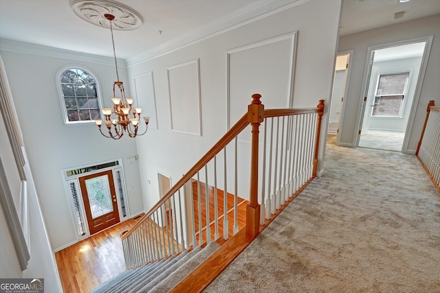 interior space featuring ornamental molding, a notable chandelier, and light wood-type flooring