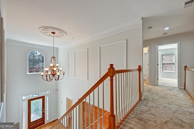 hallway with ornamental molding, light carpet, and an inviting chandelier