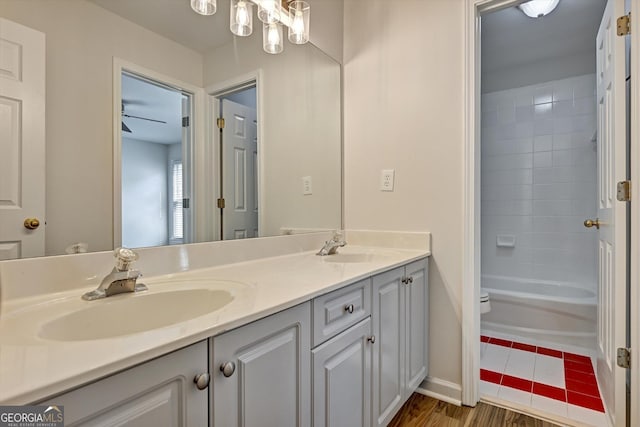 full bathroom featuring vanity, ceiling fan, tiled shower / bath combo, toilet, and wood-type flooring