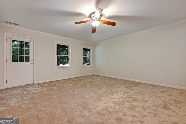 spare room with light colored carpet, ceiling fan, and crown molding