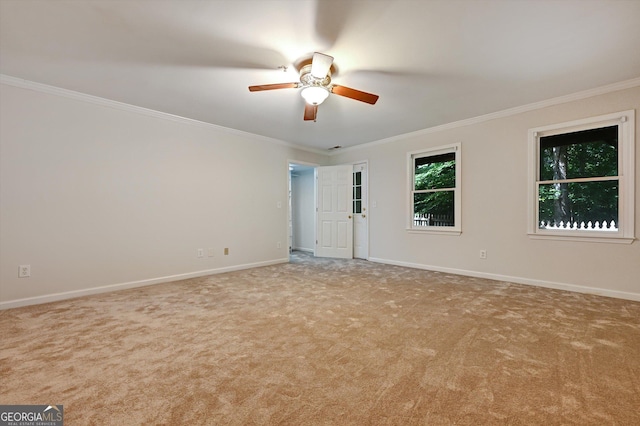 empty room featuring ceiling fan, light colored carpet, and ornamental molding