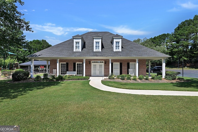 view of front of home with covered porch, french doors, and a front lawn