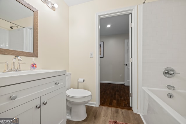 full bathroom with hardwood / wood-style floors, vanity, toilet, and tiled shower / bath