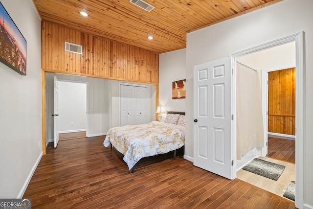 bedroom featuring wooden walls, a closet, wooden ceiling, and dark hardwood / wood-style floors