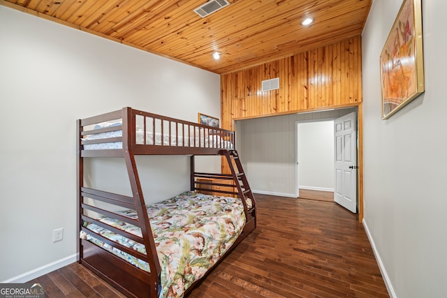 bedroom featuring wood walls, dark hardwood / wood-style flooring, and wood ceiling