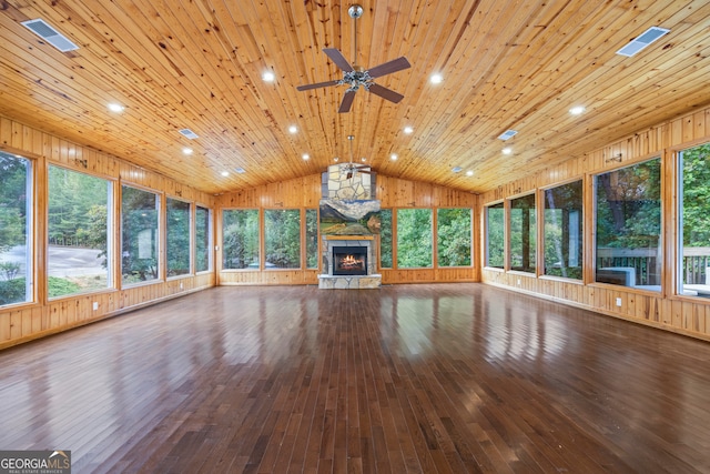 unfurnished living room featuring wood ceiling, wooden walls, wood-type flooring, a fireplace, and lofted ceiling