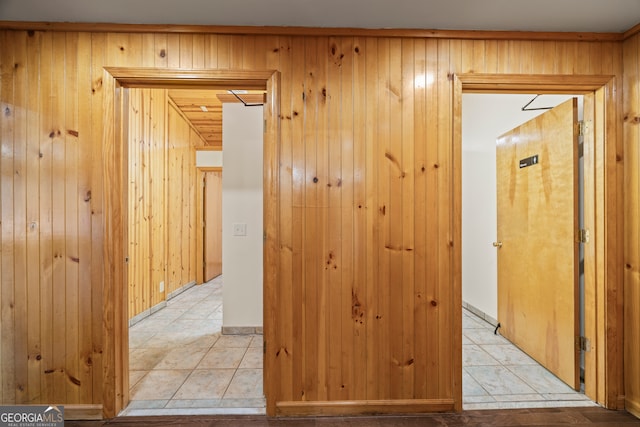 corridor with light tile patterned floors and wooden walls