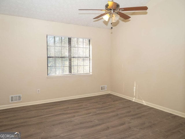 spare room with a textured ceiling, ceiling fan, and dark hardwood / wood-style floors