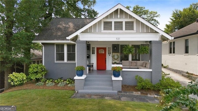 view of front of home with covered porch and a front yard