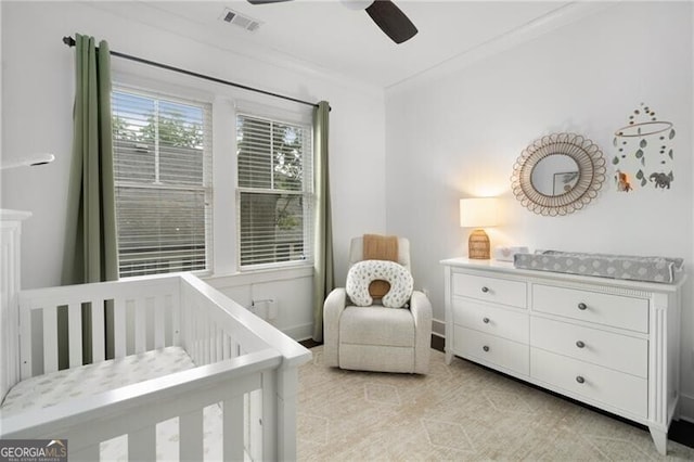 bedroom with ceiling fan, ornamental molding, and a nursery area