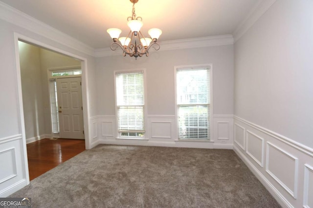 unfurnished room featuring dark carpet, crown molding, and a notable chandelier