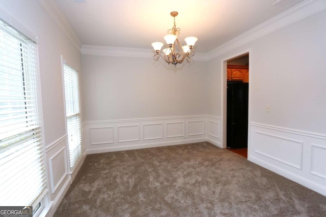 carpeted empty room featuring crown molding and a chandelier