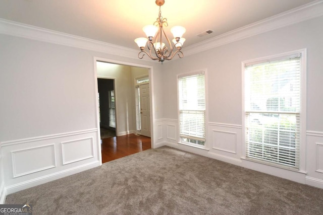 carpeted spare room featuring an inviting chandelier and ornamental molding