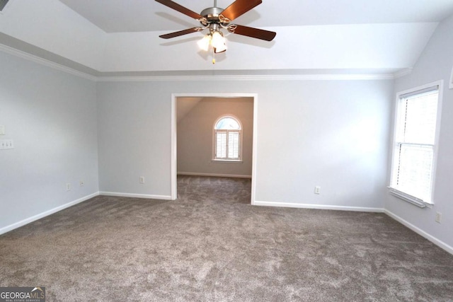 carpeted spare room featuring ceiling fan, a healthy amount of sunlight, and crown molding