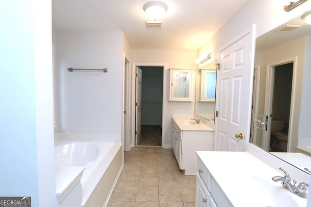 bathroom with a bathtub, tile patterned floors, toilet, and vanity