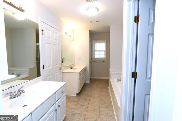 bathroom with a tub to relax in, tile patterned floors, and vanity