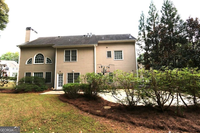 back of property featuring a patio area and a lawn