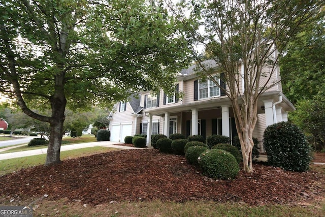 colonial inspired home featuring a garage and covered porch