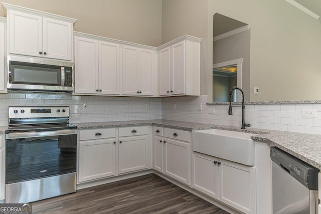 kitchen with white cabinetry, sink, light stone counters, crown molding, and appliances with stainless steel finishes