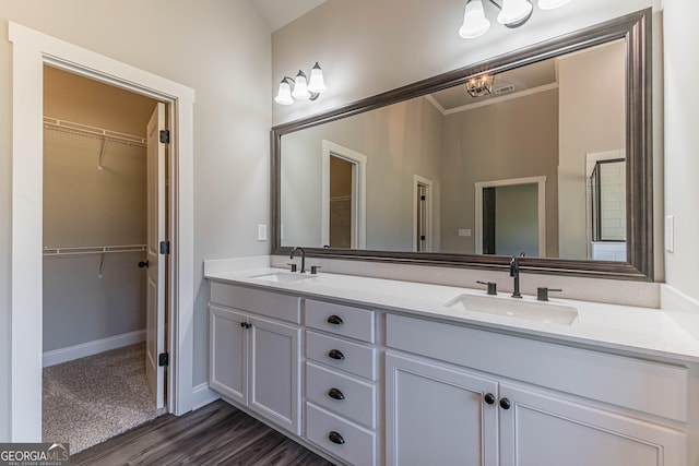 bathroom featuring hardwood / wood-style flooring, vanity, and ornamental molding